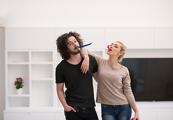 Image showing couple in party hats blowing in whistle