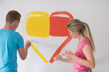 Image showing couple are painting a heart on the wall