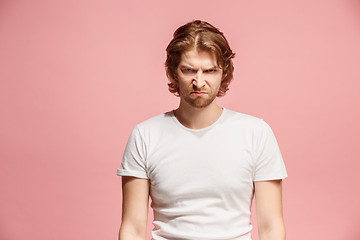 Image showing Portrait of an angry man looking at camera isolated on a pink background