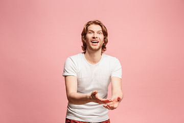 Image showing Beautiful male half-length portrait isolated on pink studio backgroud. The young emotional surprised man