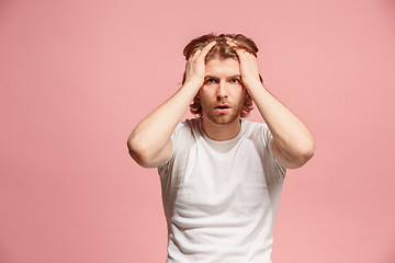 Image showing man having headache. Isolated over pink background.