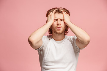 Image showing man having headache. Isolated over pink background.