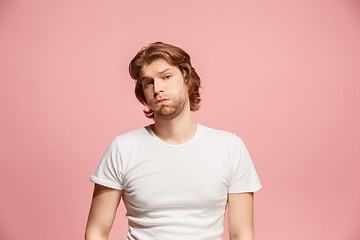Image showing Beautiful man looking suprised and bewildered isolated on pink
