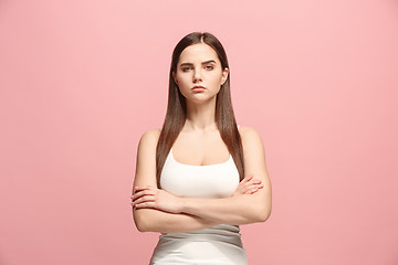 Image showing The serious business woman standing and looking at camera against pink background.