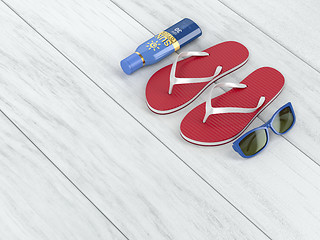 Image showing Flip-flops, sun cream and sunglasses