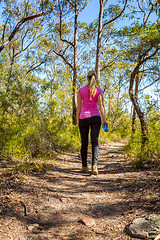 Image showing Female walking along a bush track among nature