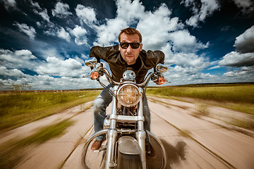 Image showing Biker racing on the road