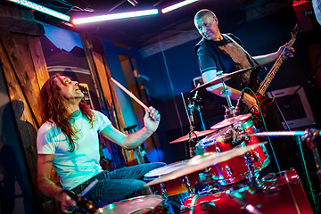 Image showing Drummer playing on drum set on stage.