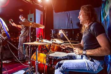 Image showing Drummer playing on drum set on stage.