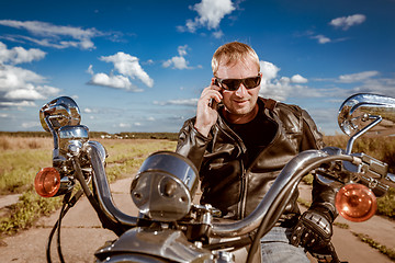 Image showing Biker talking on a smartphone.