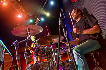 Image showing Drummer playing on drum set on stage.