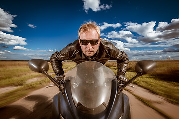 Image showing Biker racing on the road