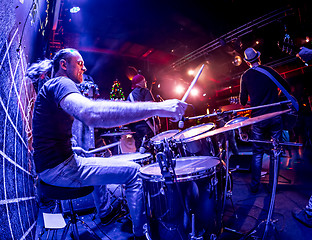 Image showing Drummer playing on drum set on stage.