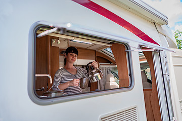 Image showing Woman cooking in camper, motorhome interior