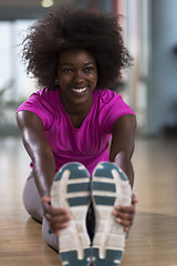 Image showing woman in a gym stretching and warming up before workout