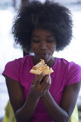 Image showing woman with afro hairstyle eating tasty pizza slice