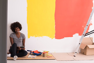 Image showing back female painter sitting on floor