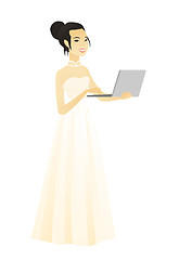 Image showing Asian bride in a white dress using a laptop.