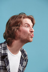 Image showing Portrait of attractive cute man with kiss isolated over blue background