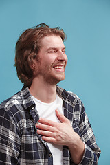 Image showing The happy businessman standing and smiling against blue background.