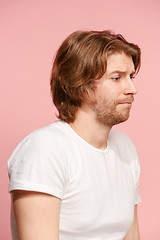 Image showing Let me think. Doubtful pensive man with thoughtful expression making choice against pink background