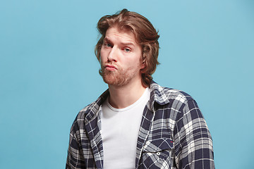 Image showing Let me think. Doubtful pensive man with thoughtful expression making choice against blue background