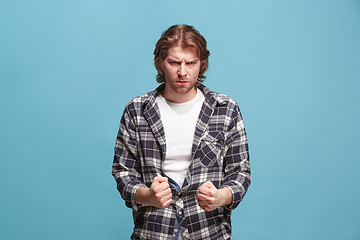 Image showing Portrait of an angry man looking at camera isolated on a blue background