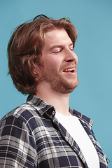 Image showing The happy businessman standing and smiling against blue background.