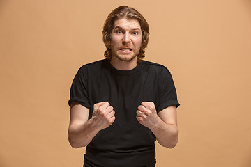 Image showing The young emotional angry man screaming on pastel studio background