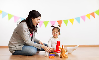 Image showing mother and baby daughter playing with pyramid toy