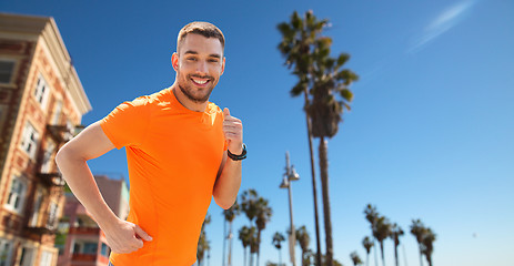 Image showing smiling young man running at summer seaside