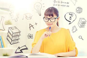 Image showing smiling young asian woman reading book at home