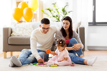 Image showing baby girl with parents playing with pyramid toy