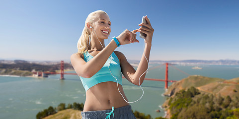 Image showing woman with smartphone and earphones doing sports