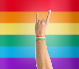 Image showing hand with gay pride rainbow wristband shows rock