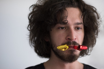 Image showing Portrait of a man in party hat blowing in whistle