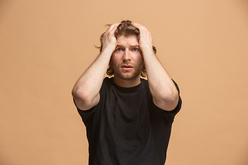 Image showing The young emotional angry and scared man standing and looking at camera
