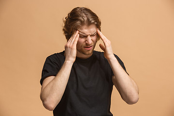 Image showing Man having headache. Isolated over pastel background.