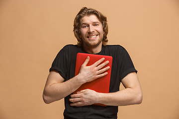 Image showing Businessman hugging laptop at studio