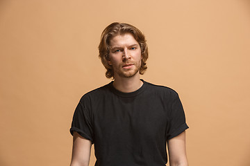 Image showing The serious businessman standing and looking at camera against pastel background.