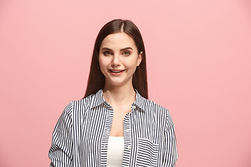 Image showing The happy business woman standing and smiling against pink background.