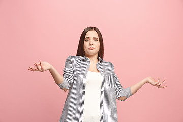 Image showing Beautiful female half-length portrait isolated on pink studio backgroud. The young emotional surprised woman