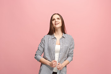 Image showing The happy business woman standing and smiling against pink background.