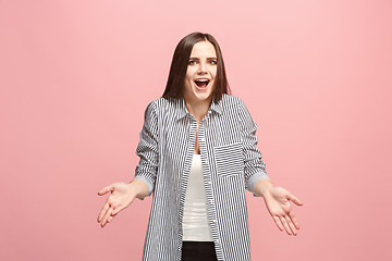 Image showing Beautiful female half-length portrait isolated on pink studio backgroud. The young emotional surprised woman