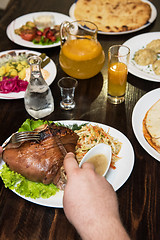 Image showing Man eats tasty dish of pork shank