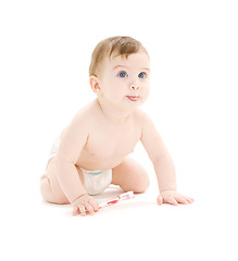 Image showing baby boy in diaper with toothbrush sticking tongue out