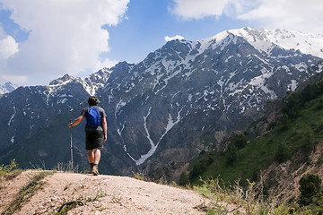 Image showing Young tourist in mountains with a walking pole