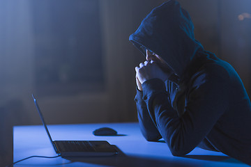 Image showing hacker with laptop computer in dark room