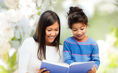 Image showing happy mother and daughter reading book