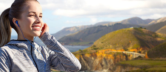 Image showing close up of woman listening to music in earphones